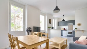A modern apartment with a dining area, kitchen, and living space. - Charming apartment located 10 min from the seaside (Marseille)