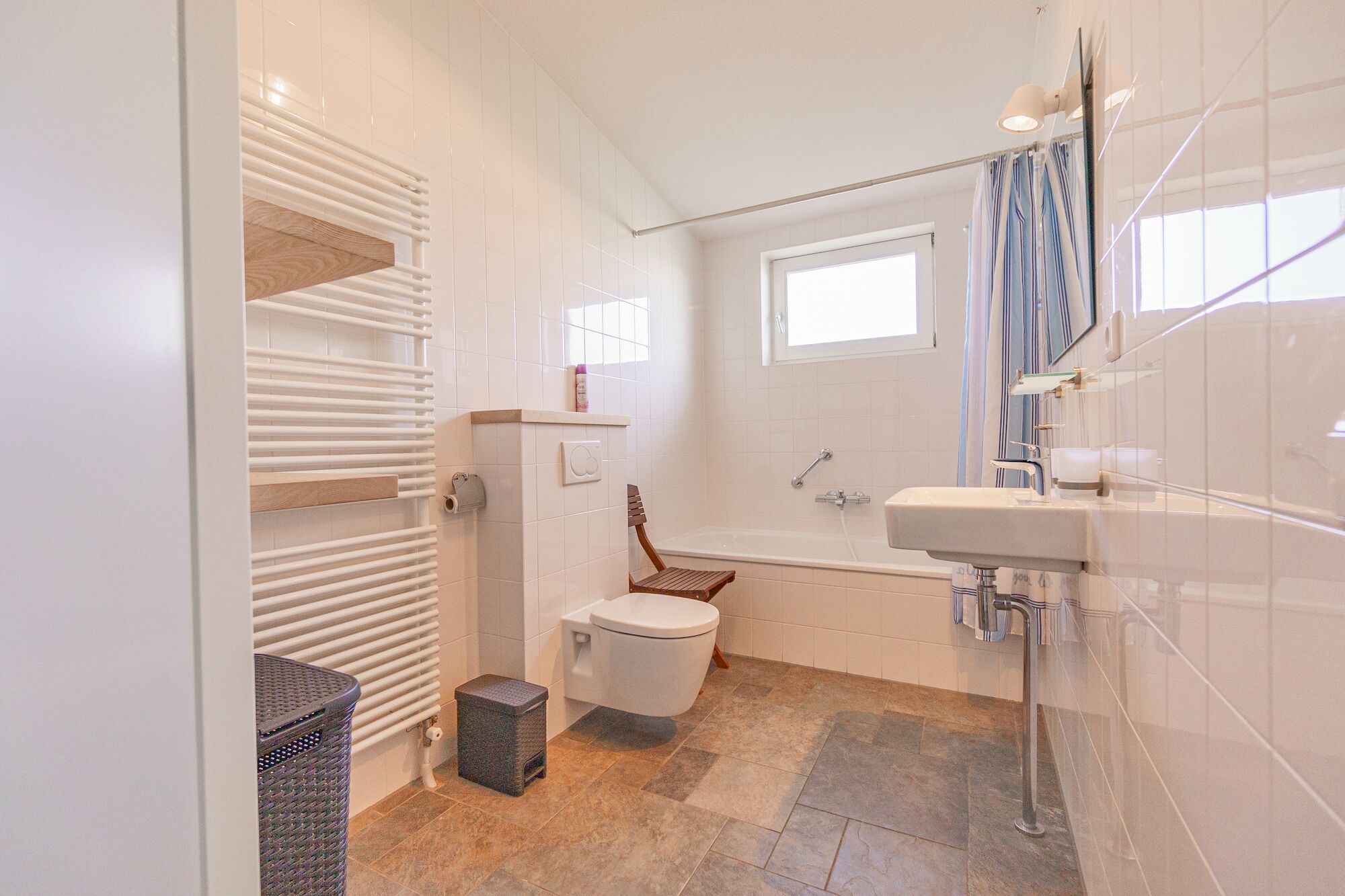 A modern bathroom with a toilet, bathtub, and sink.