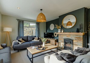 Relax in a cozy seating area with a fireplace, flat-screen TV, and large window.