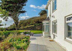 Enjoy a serene garden and patio area with a scenic hillside view.