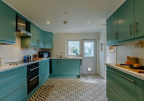 Enjoy cooking in this kitchen with a sink, stove, and microwave, offering a view of the outside.