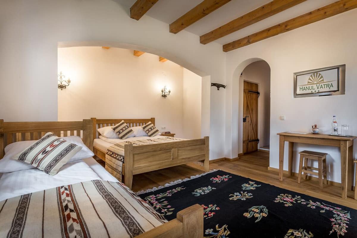 A cozy room with two wooden beds, a desk, and a chair.