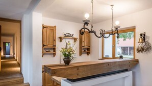 A kitchen with wooden cabinets, a central island, and pendant lighting. - Hanul Vatra (Costesti)