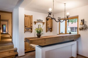 Cocina con armarios de madera, una isla central e iluminación colgante.