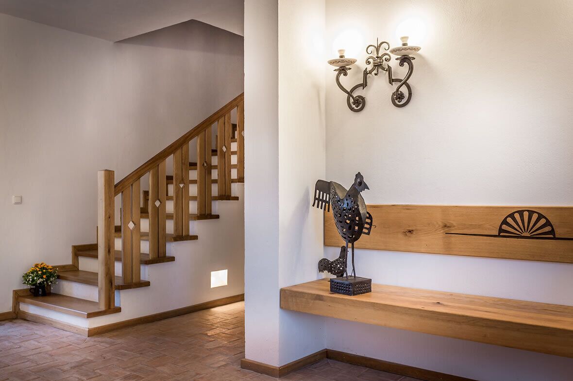 Una escalera de madera con un banco e iluminación empotrada en la pared.
