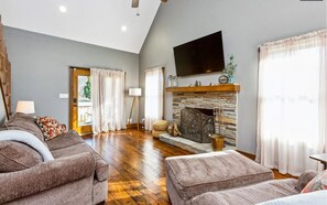 Relax in this inviting living room with a stone fireplace, flat-screen TV, and comfortable sectional sofa.
