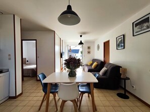 Un espace repas comprenant une table, des chaises et un luminaire suspendu.