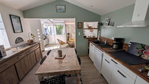 Une cuisine moderne avec des meubles en bois, une table à manger et une vue sur le salon attenant.