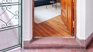 A hallway with a wooden door, a dark blue sofa, and a white rug. - w* | Elegant & Bright 2BR in Prime Polanco (Ciudad de México)