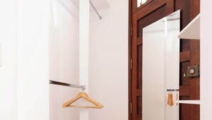 A hallway with a wooden floor, a white door with a mirror, and a wooden hanger on a white pole. - w* | Elegant & Bright 2BR in Prime Polanco (Ciudad de México)