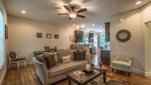 A living room with a sofa, coffee table, and a ceiling fan. - Be our guest-3-bedroom house in a great location! (Fletcher)