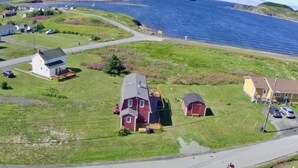 A coastal residential area with houses, a road, and a body of water. - Red Sunset Cottage in Twillingate (Twillingate)
