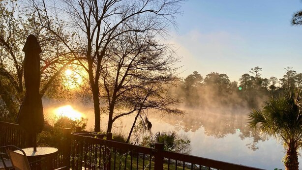 A deck with chairs overlooking a body of water, trees, and a sunrise. - The Robin House, Newly Furnished Lake Retreat Near Tybee Island & Savannah (Wilmington Island)