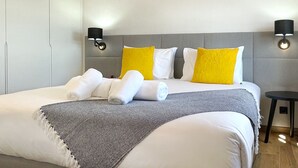 A hotel room with a large bed, two bedside lamps, and a small table. - Stylish 1 Bedroom Stone House With Sea View In São Jorge, Azores (Belo Malandro) (São Jorge)