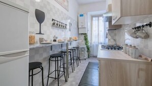 Una cocina moderna con una isla central, taburetes de bar, horno empotrado y un colgador para ollas.