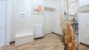 Un interior moderno con un banco blanco, un radiador y una planta decorativa.