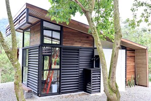 Et moderne hus med træfacade, store vinduer og en grusbelagt indkørsel.