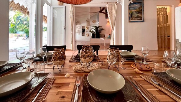 A dining area with a wooden table set for a meal, featuring woven baskets and bamboo placemats.