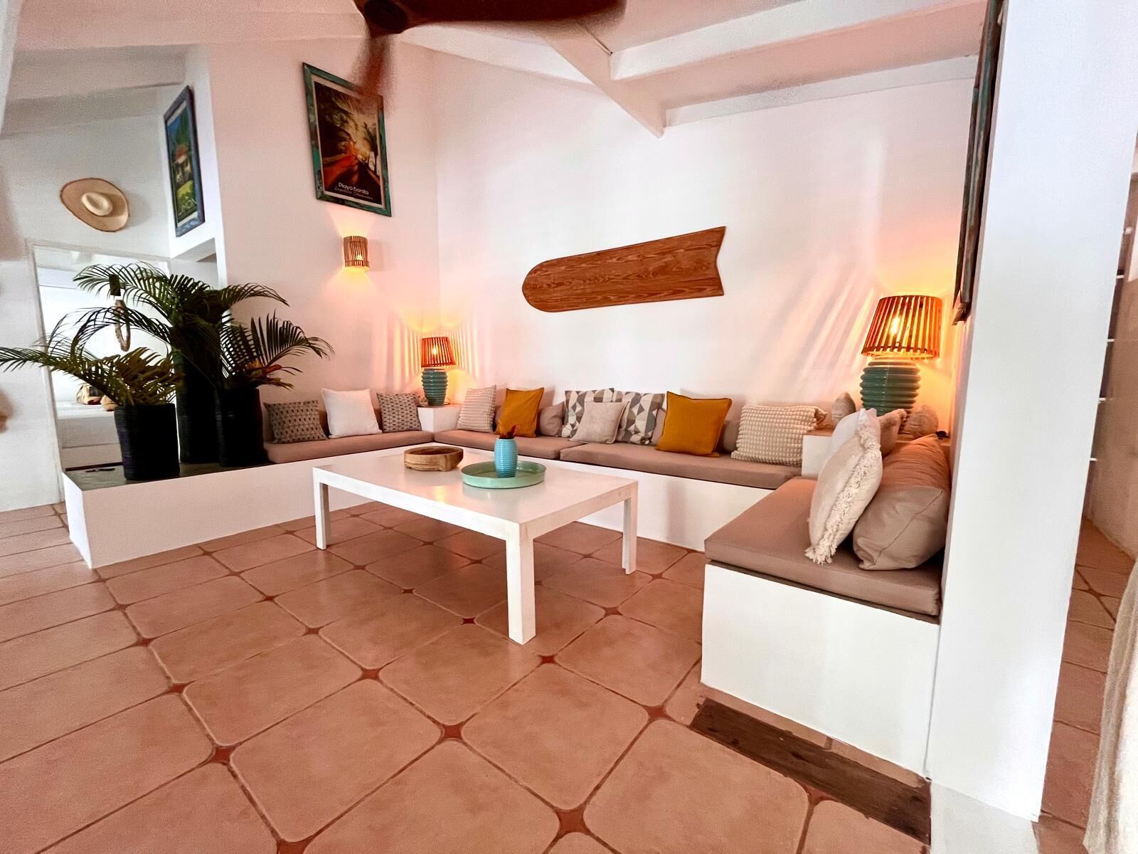 A modern living room with a white sofa, a coffee table, and a large wooden accent wall.