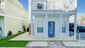 Ein zweistöckiges Wohngebäude mit Balkon, Eingangstür und Garage.