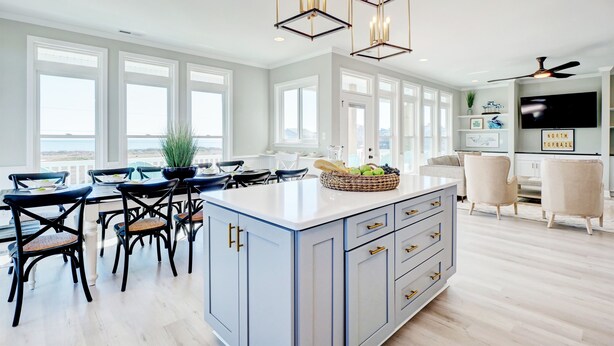 A spacious kitchen with a large island, white cabinetry, and a dining area with black chairs. - Spacious Luxe Home|Private Pool/Hot Tub (North Topsail Beach)