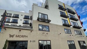 Ein mehrstöckiges Gebäude mit einer Schaufensterfront mit der Aufschrift "MORPH" und der Adresse "8-20".