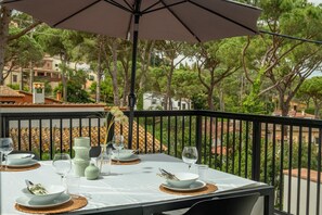 A table set outdoors with a view of a residential area and trees. - Newly built house with private pool (Begur)