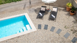 A rooftop pool area with lounge chairs, a white umbrella, and potted plants. - Newly built house with private pool (Begur)