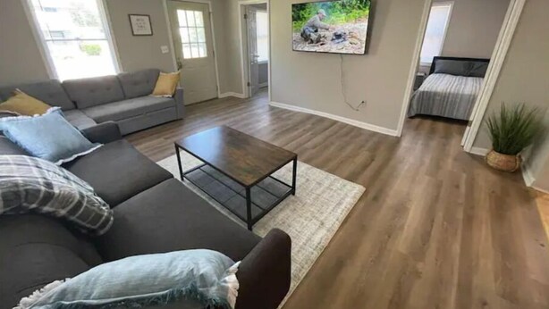 A living room with a sofa, coffee table, and a painting on the wall.