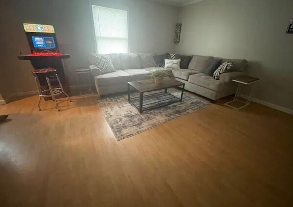A living room with a sofa, coffee table, and a small table with a lamp.