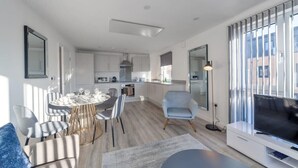 A modern apartment with a dining area, kitchen, and living room. - Contemporary 2 Bedroom Apartment in Ashford (Ashford)