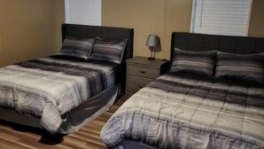 Ein Schlafzimmer mit zwei Betten, einem Deckenventilator und Holzboden.