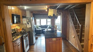 Un intérieur en bois comprenant une cuisine, un coin repas et un escalier.
