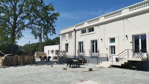 A building under construction with a flat roof, large windows, and a staircase leading to the entrance.