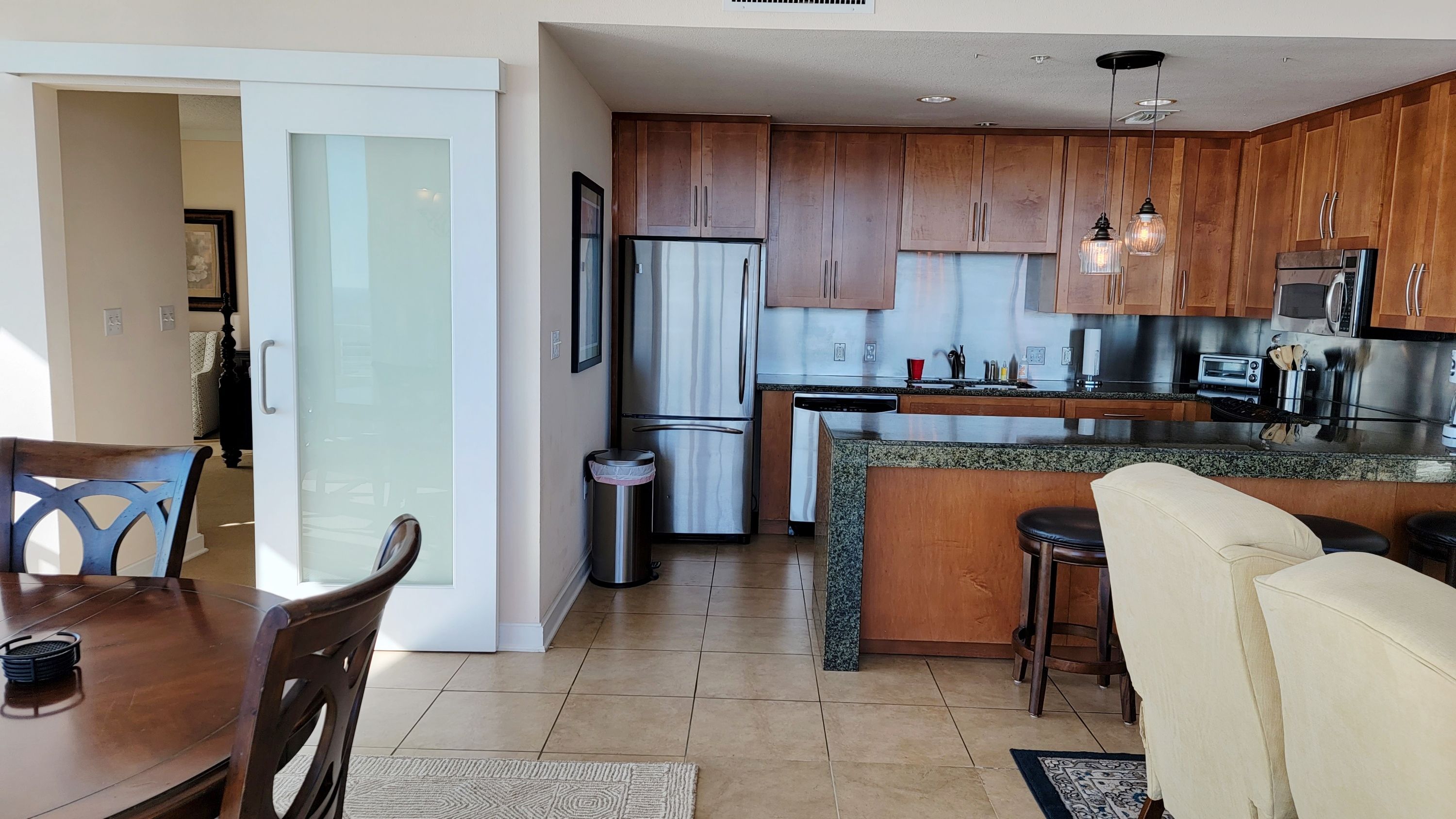 A modern kitchen with wooden cabinets, stainless steel appliances, and a granite countertop.