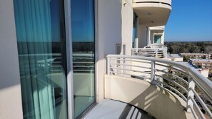 A balcony with a glass door and a white railing. - Ocean Club 805 Deluxe | Stunning Panoramic Views of the Gulf! (Biloxi)