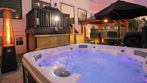 Un jacuzzi con cubierta de madera y un patio amoblado al aire libre.