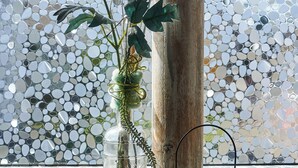 A vase with a pink flower and a bird figurine on a windowsill. - Ferienwohnung Rebe (Günzburg)