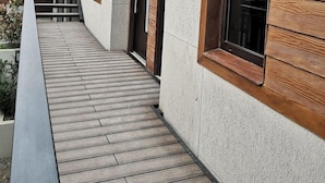 A modern building with a wooden deck leading to a set of stairs.