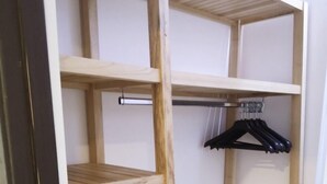 A wooden shelving unit with multiple open shelves and a hanging rack.