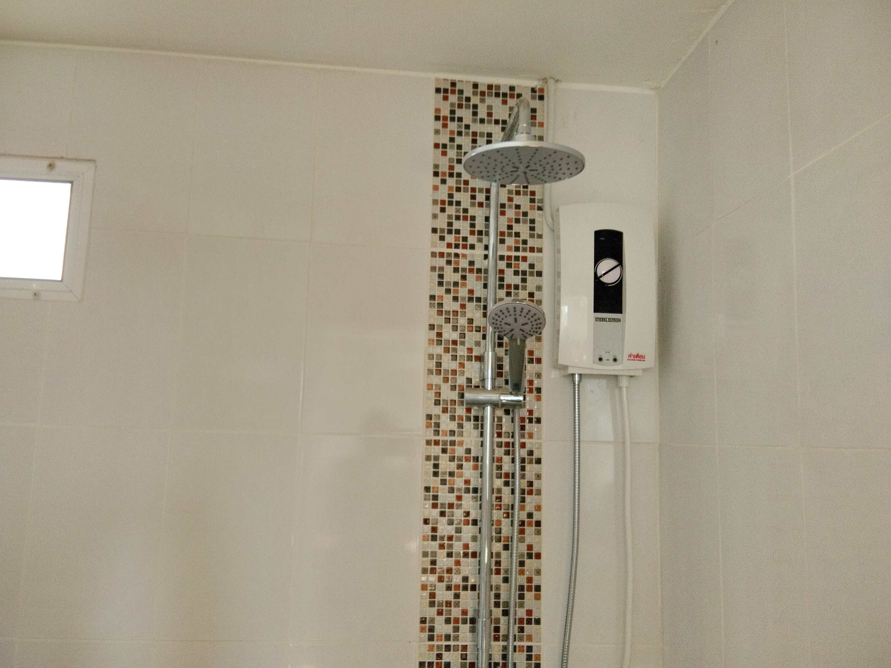 Ducha con cabezal de lluvia y panel de control en la pared.