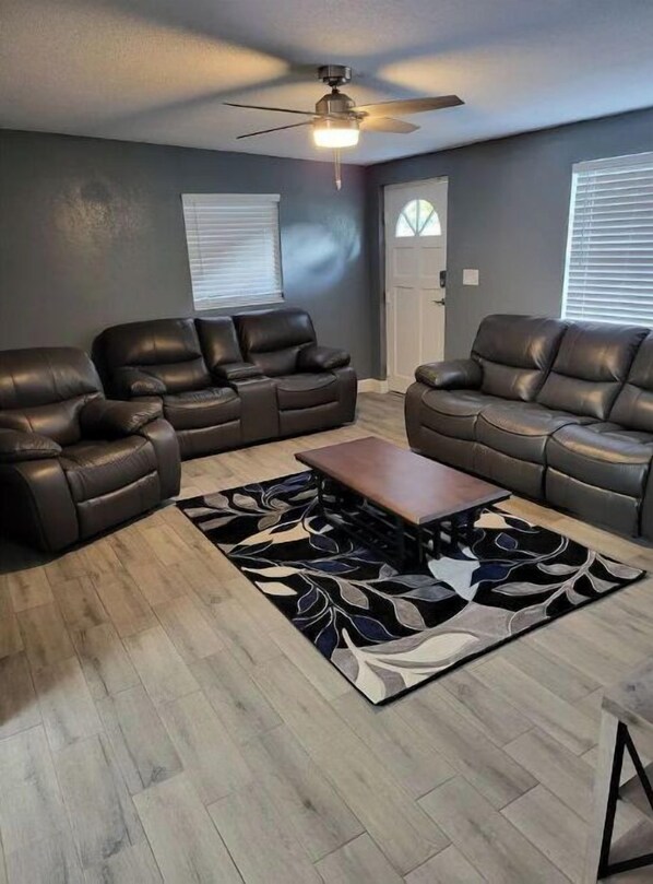 A modern living room with two leather sofas, a wooden coffee table, and a patterned rug. - Legoland 3 Bedroom Pet Friendly Pool Home (Winter Haven)