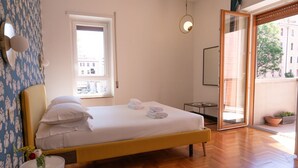 Un dormitori amb un llit, una finestra, una porta i una planta en test.