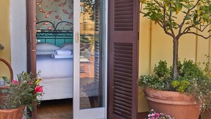 Une pièce avec un lit, une fenêtre donnant sur un paysage agréable, une porte et une plante en pot.