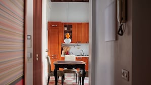 Une cuisine avec des meubles de rangement en bois, une table et des chaises.
