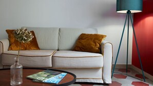 Un salon moderne avec un canapé, une lampe sur pied, une table basse et un magazine.