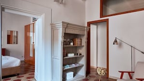 Une chambre d’hôtel avec un lit, une bibliothèque, un bureau avec une lampe et une chaise.