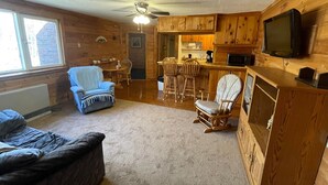 Een gezellig cabin interieur met een eethoek, keuken en zithoek.
