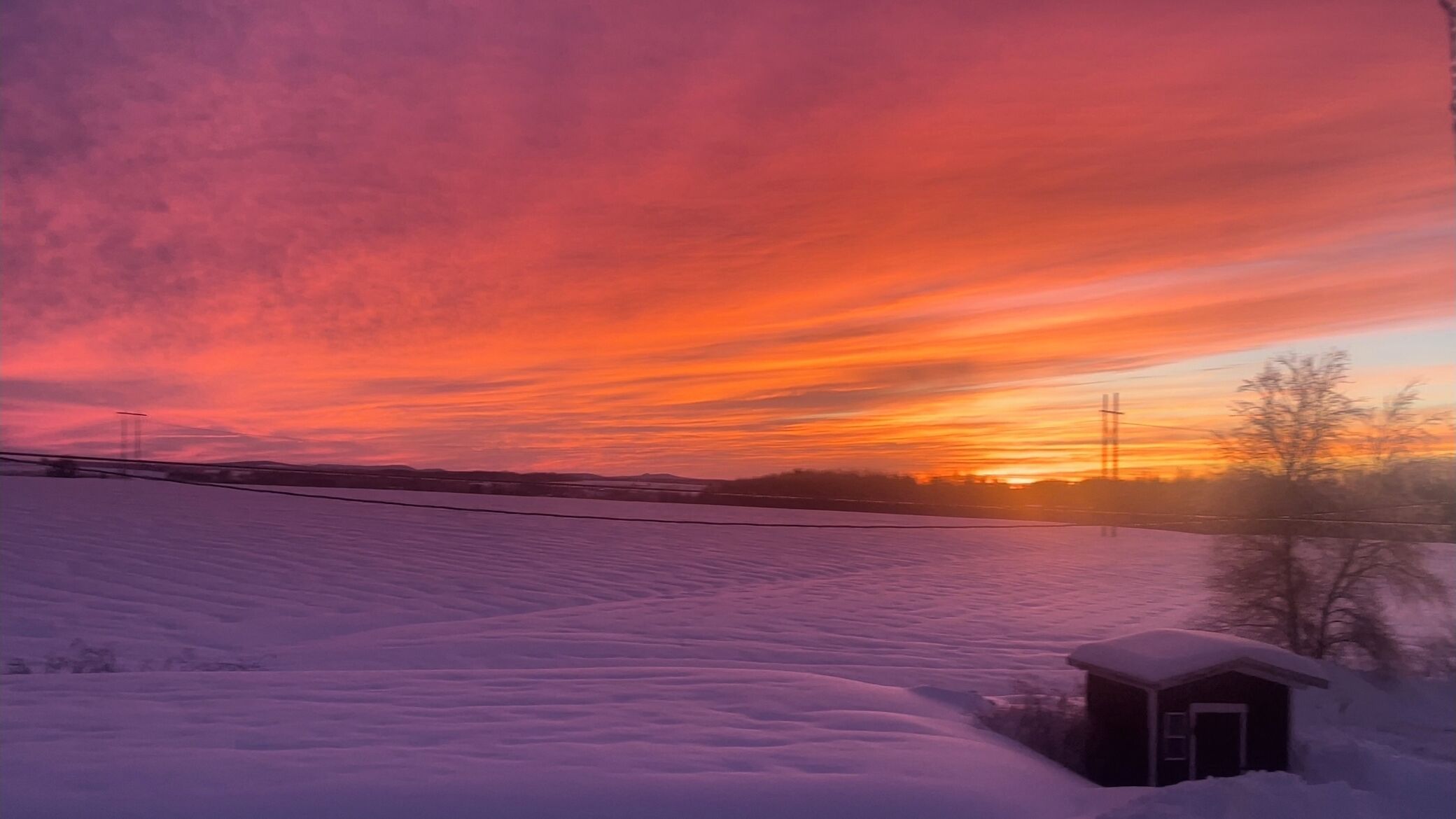 Un paisaje nevado con un atardecer.