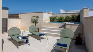 A rooftop terrace with two lounge chairs, a small table, and a pool. - Hommyhome Tetuán 15 Boutique - 101 (Sevilla)